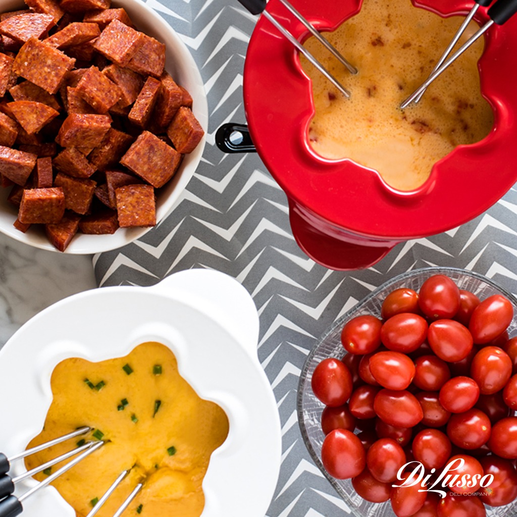 Two types of Di Lusso fondue with hard salami and cherry tomatoes