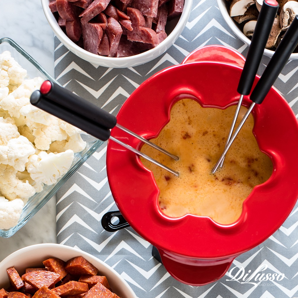 Cheese Fondue with multiple skewers, and meat and vegetables to dip